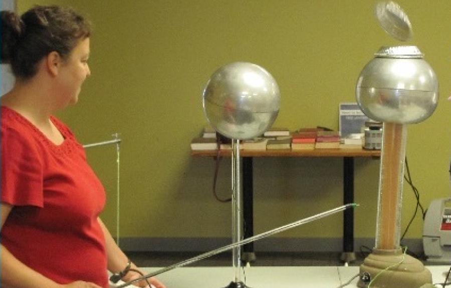 Jenny Wurster operating a Van de Graaff generator with levitating aluminum pie plates.
