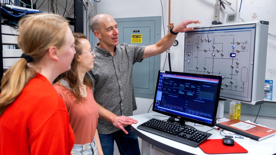 Michael Niemack, professor of physics and astronomy, works with grad student Alicia Middleton, center, and REU summer undergraduate researcher Isla Steinman in Niemack’s lab in the Physical Sciences Building.