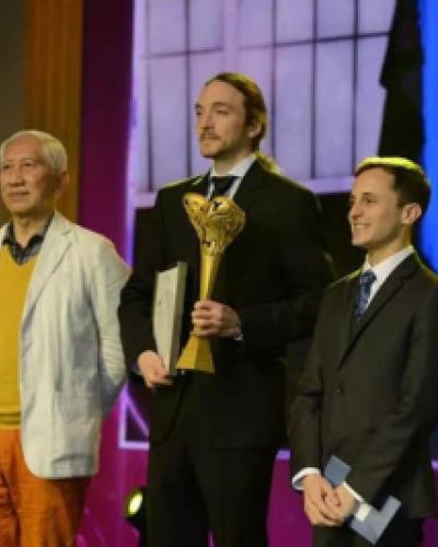 Physics graduate student Neal Reynolds, center, accepts the Upstyle Star Award for Concept Design on behalf of Team GameWear.